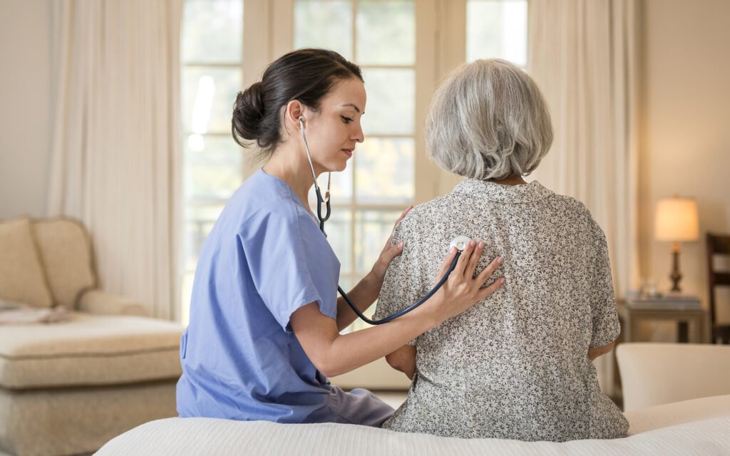 Krankenschwester hört zu Hause Brust des Patienten